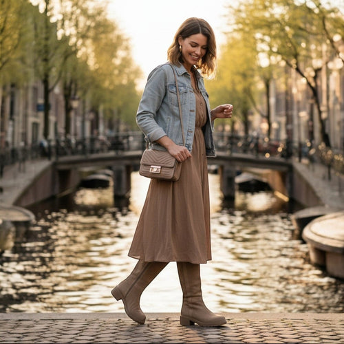 So and Ro beige micro suede knee-high boots with side zipper and block heel worn by a woman walking outdoors.