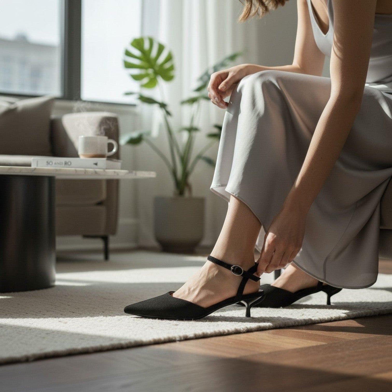 So and Ro black matte pointed toe slingback kitten heel with ankle strap and buckle closure.